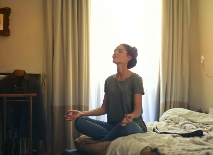 woman meditating in bedroom