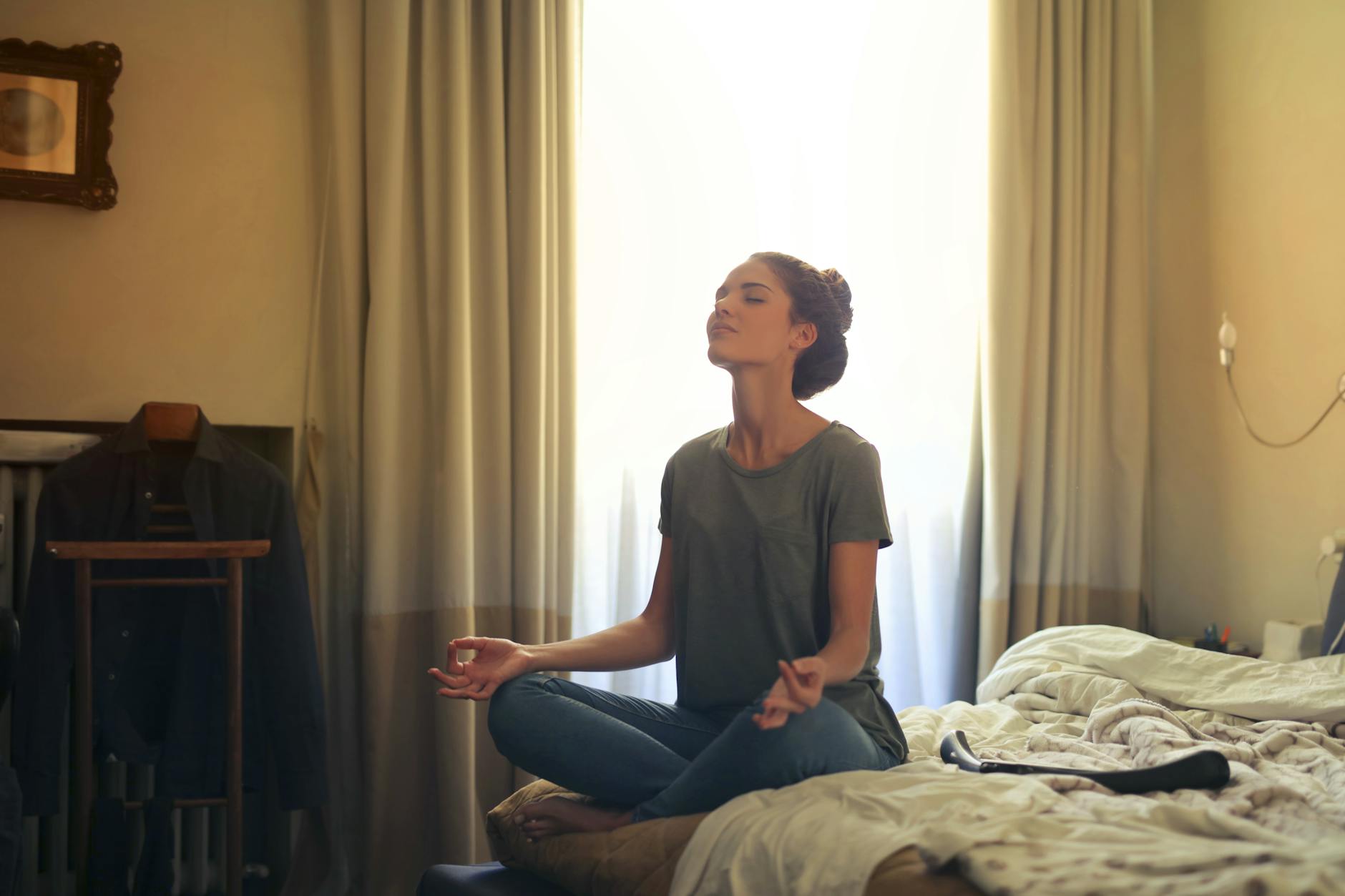 woman meditating in bedroom